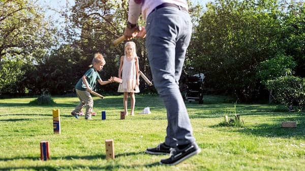 Family playing a game of Kubb in the backyard